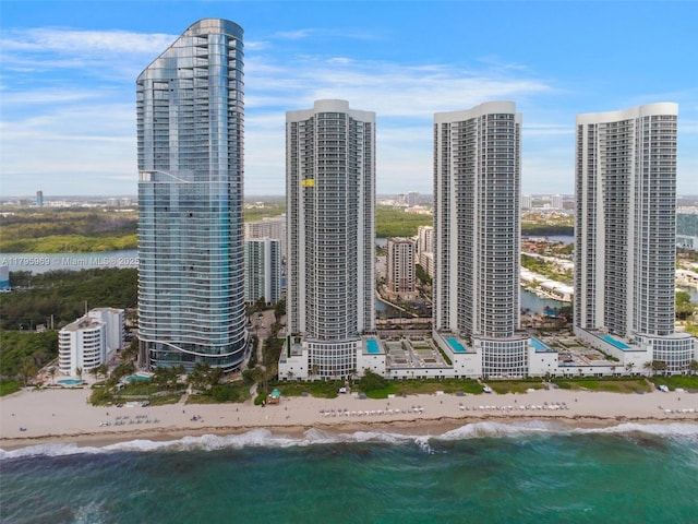 drone / aerial view with a water view, a view of city, and a beach view