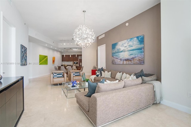 living area featuring baseboards and a notable chandelier