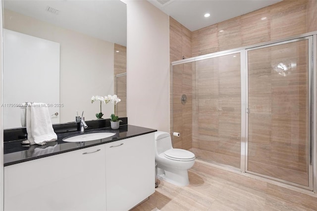 bathroom with vanity, a stall shower, and toilet