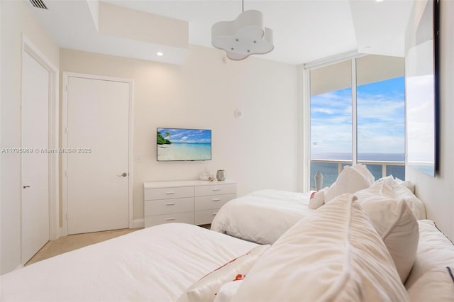 bedroom with light carpet, recessed lighting, and expansive windows