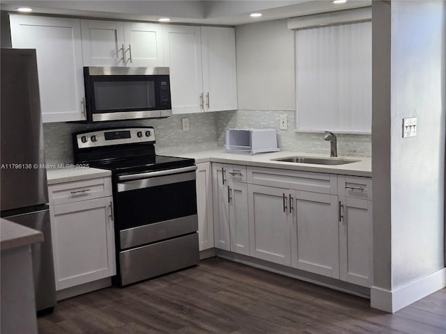 kitchen featuring white cabinets, stainless steel appliances, dark wood-style floors, and a sink