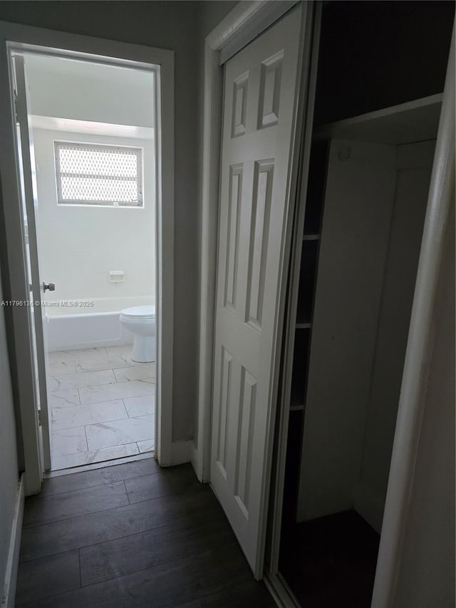 hall featuring baseboards and dark wood-style floors