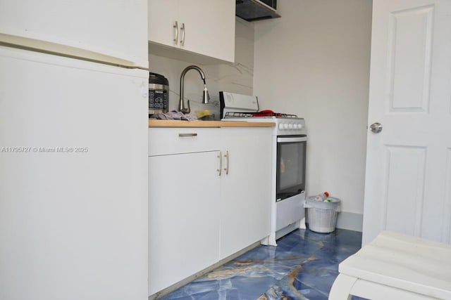 kitchen featuring white cabinets, refrigerator, butcher block countertops, and gas range gas stove