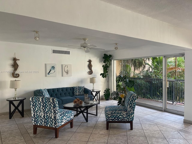 living area featuring visible vents, a ceiling fan, and light tile patterned floors