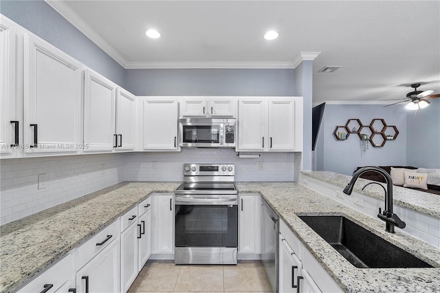 kitchen featuring crown molding, stainless steel appliances, decorative backsplash, and a sink