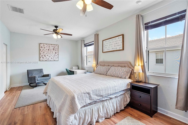 bedroom with a ceiling fan, baseboards, visible vents, and light wood-style floors