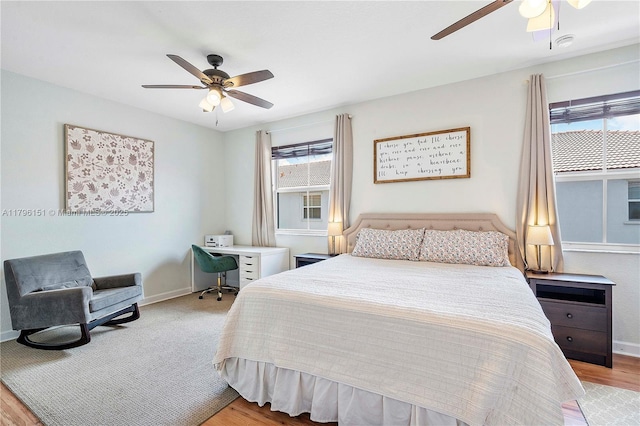bedroom featuring baseboards, a ceiling fan, and light wood-style flooring