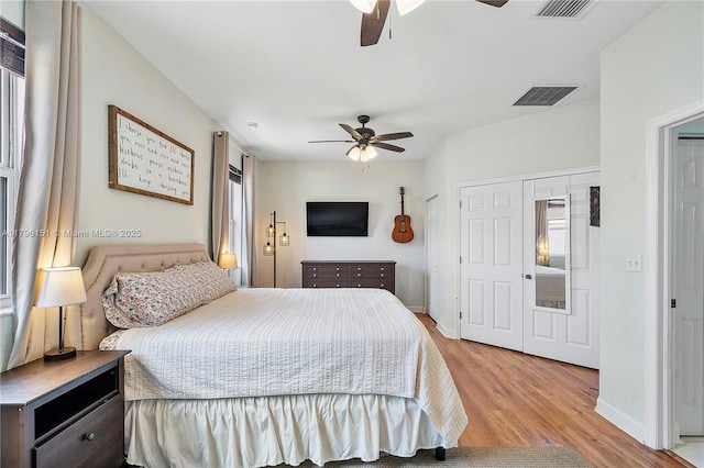bedroom featuring visible vents, a ceiling fan, and light wood-style floors