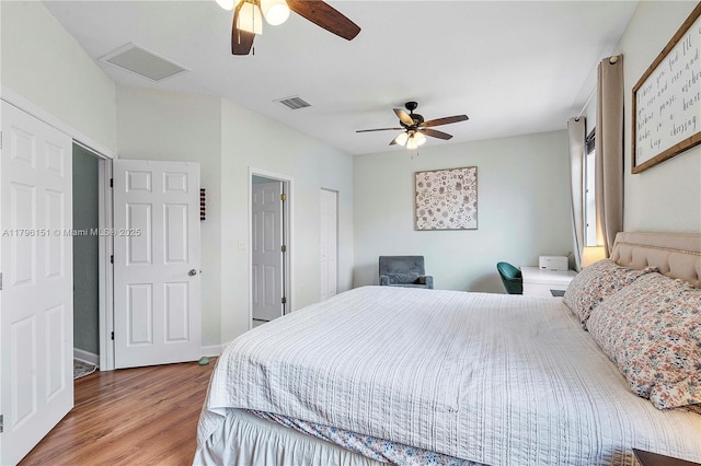 bedroom with visible vents, a ceiling fan, and wood finished floors