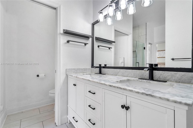 bathroom with baseboards, a sink, a stall shower, and toilet