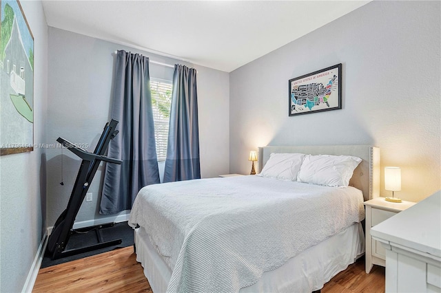 bedroom with baseboards and light wood finished floors