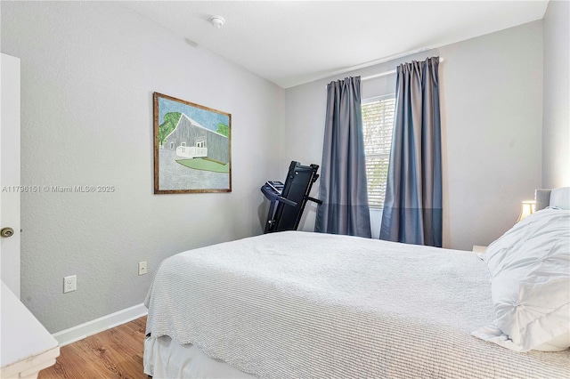 bedroom featuring baseboards and wood finished floors