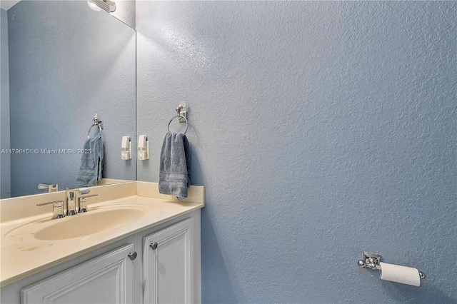 bathroom featuring vanity and a textured wall