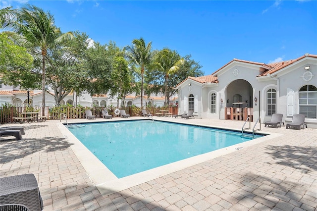 pool featuring fence and a patio area