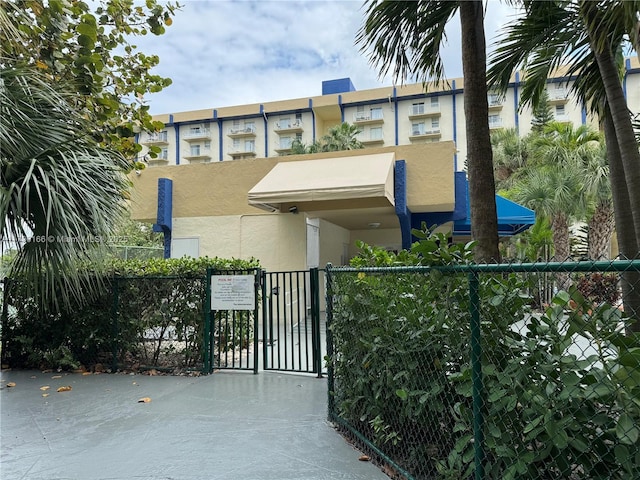 view of front of house featuring fence, a gate, and stucco siding