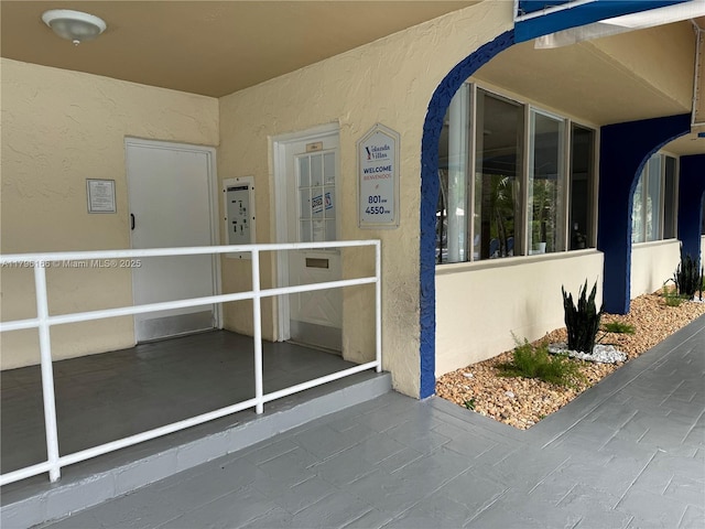 entrance to property with stucco siding
