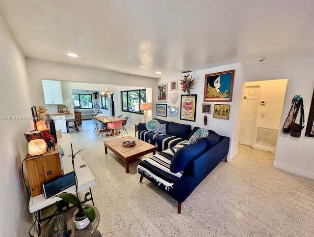 living area with an inviting chandelier, recessed lighting, and baseboards