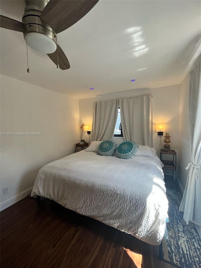 bedroom featuring baseboards, a ceiling fan, and wood finished floors