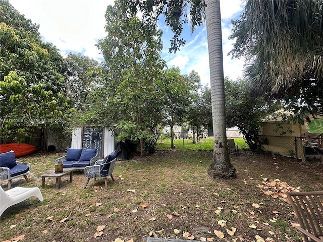 view of yard with a fenced backyard, an outbuilding, outdoor lounge area, and a storage shed