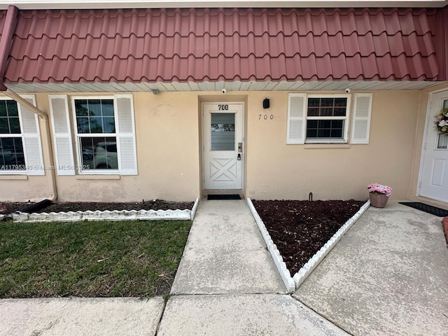 entrance to property with stucco siding and a tile roof