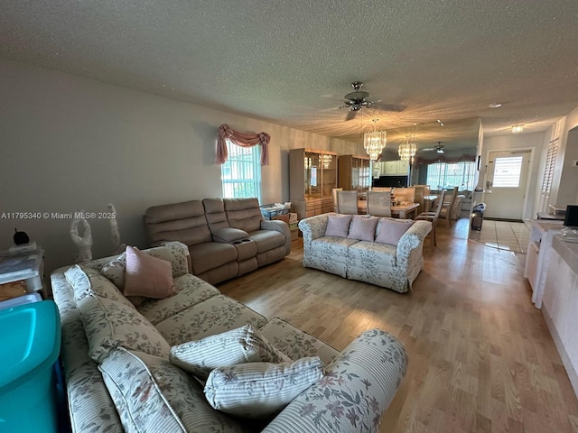 living room with plenty of natural light, a textured ceiling, and light wood finished floors