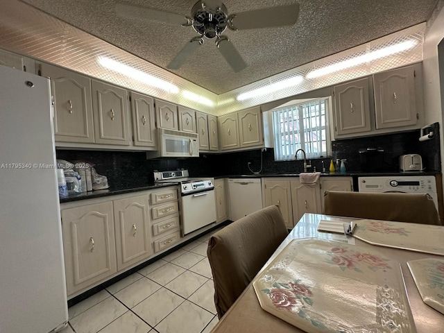 kitchen featuring decorative backsplash, a ceiling fan, dark countertops, white appliances, and a sink