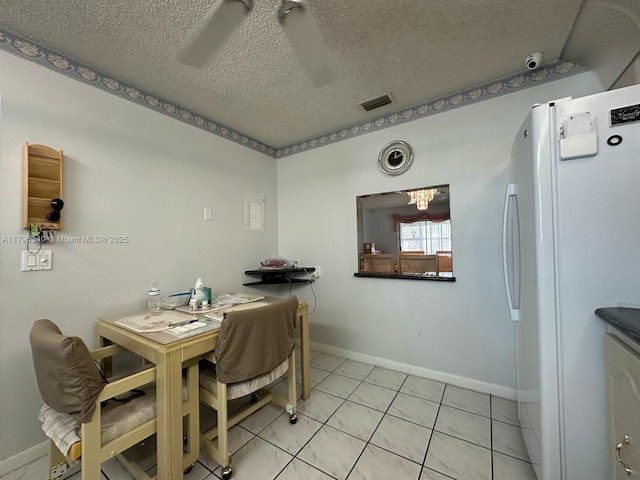 dining space featuring light tile patterned floors, baseboards, a textured ceiling, and visible vents