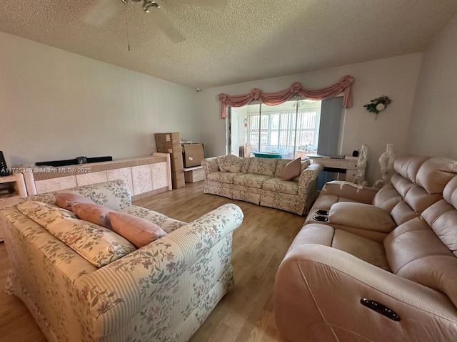 living area with a textured ceiling, ceiling fan, and wood finished floors