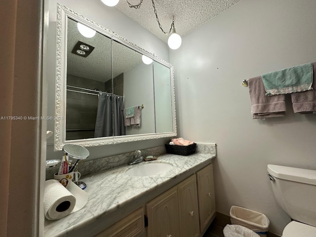 full bath with vanity, a textured ceiling, curtained shower, and toilet