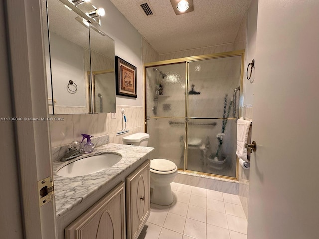 bathroom with visible vents, vanity, tile patterned flooring, and a shower stall