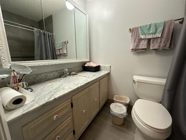 bathroom featuring vanity, toilet, a textured ceiling, tile patterned floors, and a tile shower