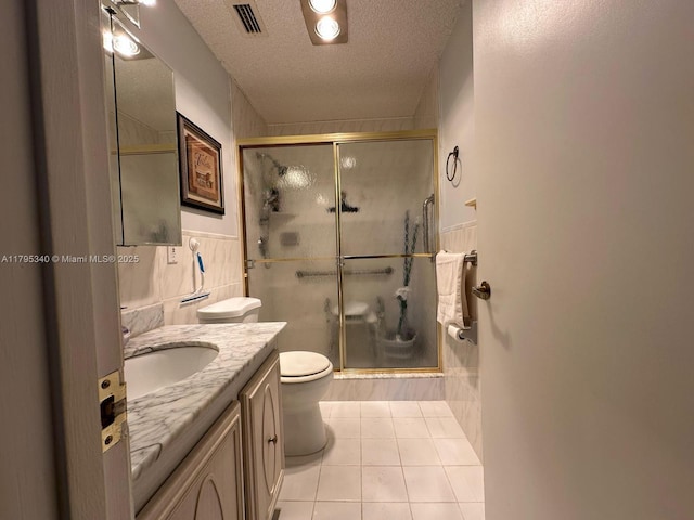 full bath with tile patterned floors, a stall shower, a textured ceiling, and visible vents