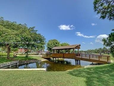 view of dock featuring a lawn and a water view