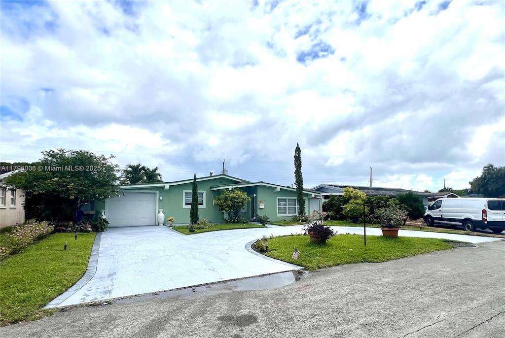 view of front facade featuring an attached garage, concrete driveway, stucco siding, and a front lawn