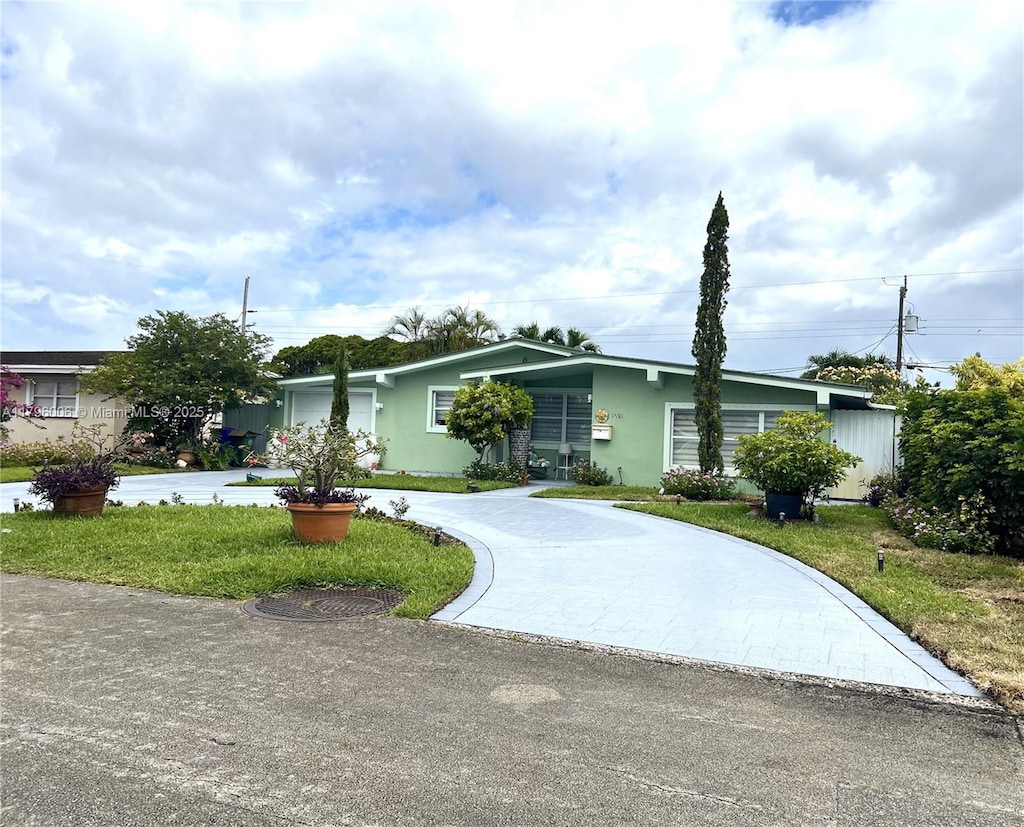 view of front of property with stucco siding, driveway, and a front yard