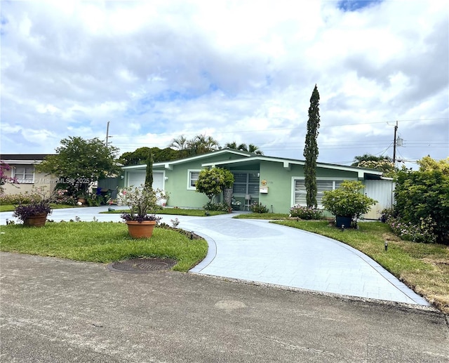 view of front of property with stucco siding, driveway, and a front yard