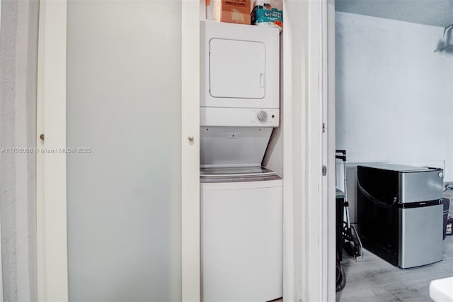 7691 NW 15th Ct, Pembroke Pines, FL 33024 - laundry room featuring stacked washer / drying machine and wood finished floors
