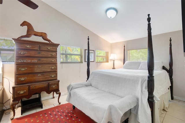 bedroom featuring baseboards, light tile patterned flooring, and vaulted ceiling