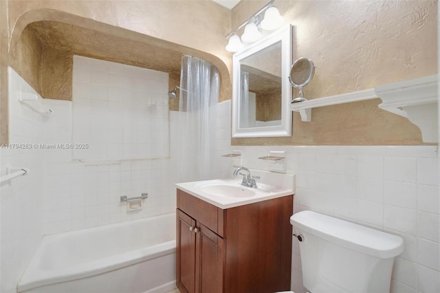 full bath featuring vanity, shower / bathtub combination, toilet, and a wainscoted wall
