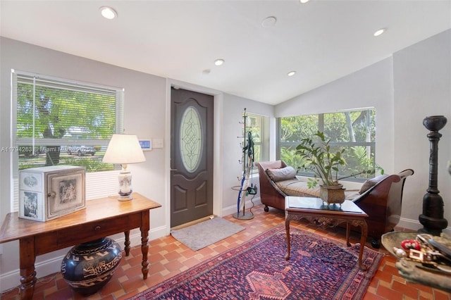 entryway with recessed lighting, baseboards, lofted ceiling, and a healthy amount of sunlight