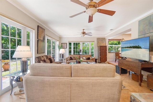living area with plenty of natural light, a ceiling fan, and light tile patterned flooring