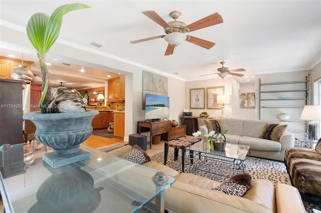 living area featuring recessed lighting, a ceiling fan, visible vents, and ornamental molding