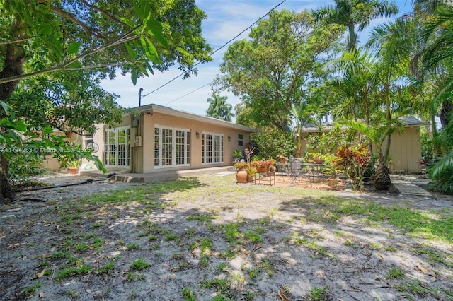 view of yard featuring a patio and french doors