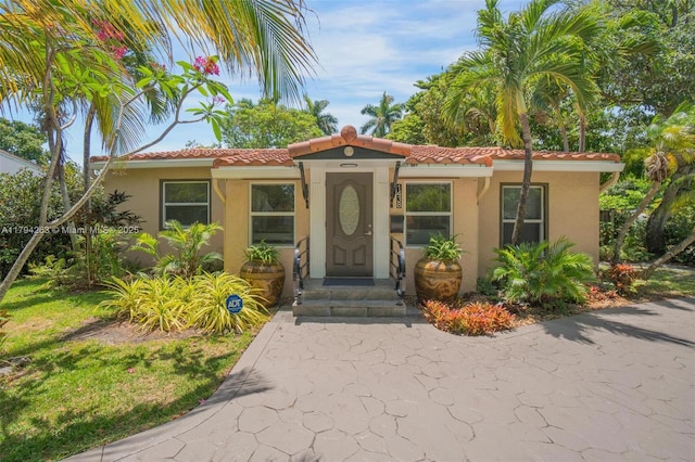 view of front of property with stucco siding and a tile roof