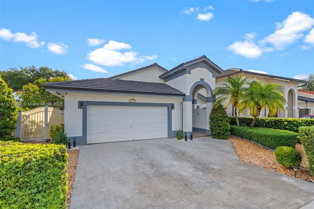 view of front of home with an attached garage, decorative driveway, stucco siding, and a tiled roof