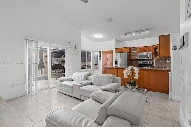 living area with visible vents, lofted ceiling, and light tile patterned floors