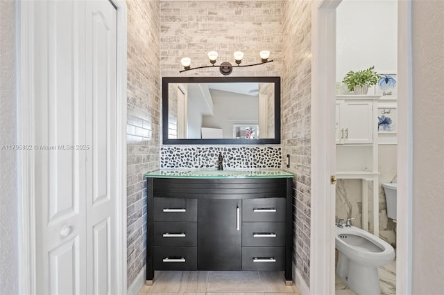 bathroom featuring vanity, a bidet, and tile walls
