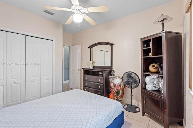 bedroom featuring visible vents, a closet, baseboards, ceiling fan, and light tile patterned floors