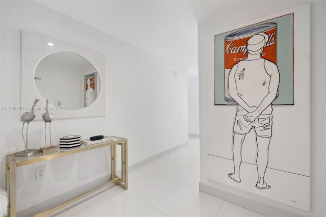 hall featuring baseboards and tile patterned floors