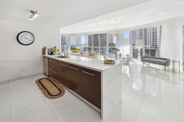 kitchen featuring an inviting chandelier, a peninsula, modern cabinets, a sink, and dishwasher